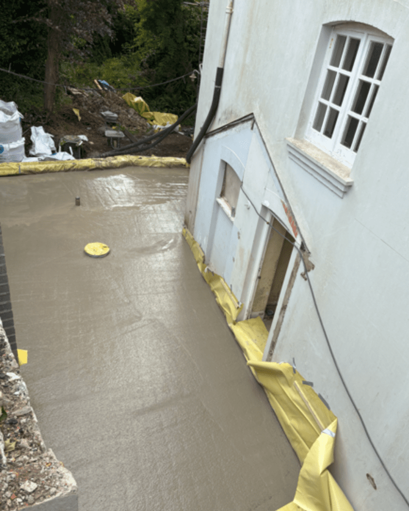 Concrete base being laid for a historical home in Tenby. 